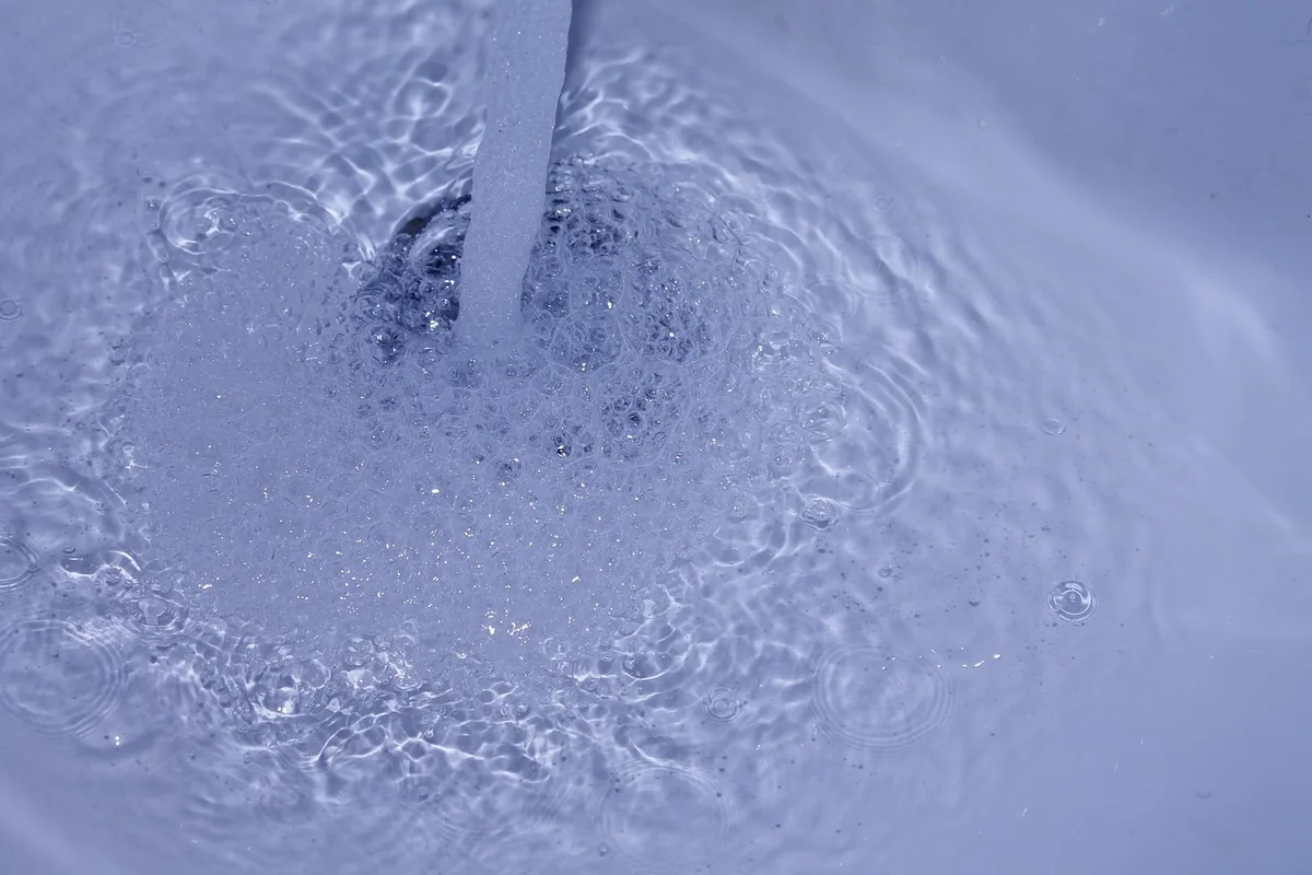 Évier avec eau qui stagne indiquant une canalisation partiellement bouchée